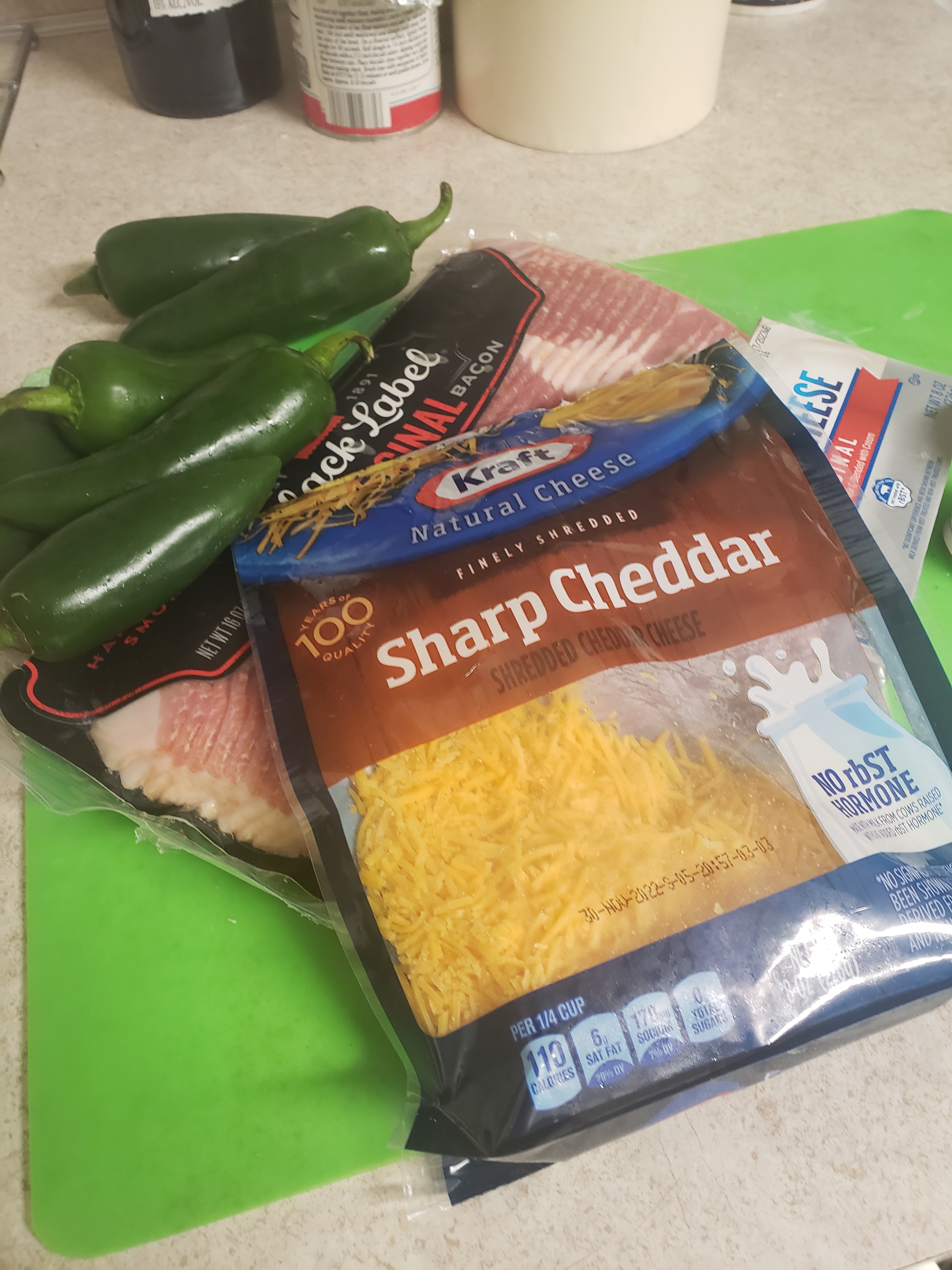 A picture of jalapenos, sharp cheddar, cream cheese, and bacon.